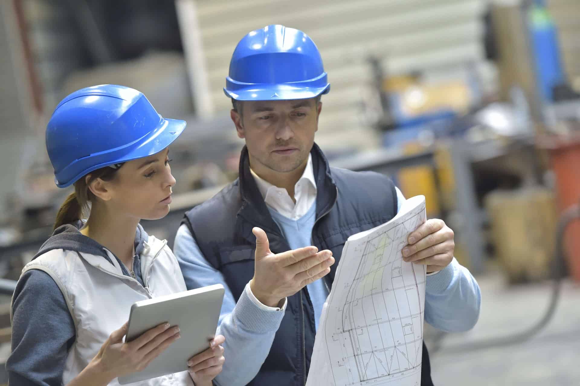 man and woman reading blueprints