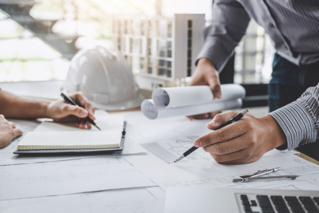 Construction and structure concept of Engineer or architect meeting for project working with partner and engineering tools on model building and blueprint in working site.